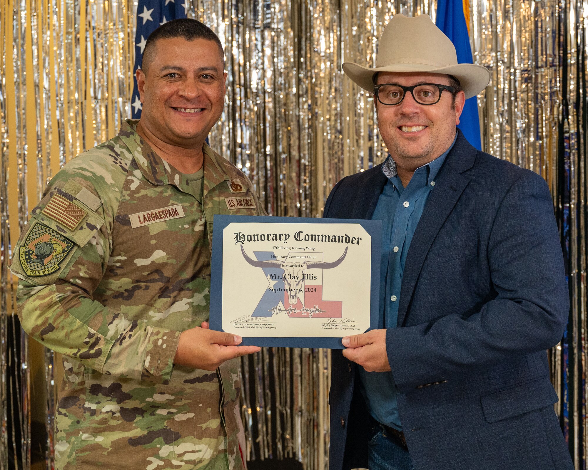 An honorary commander accepts their certificate from their commander at the honorary commander induction ceremony at Laughlin Air Force Base, Texas, Sept. 6, 2024. The honorary commander program looks to bring local community leaders and base personnel closer together, fostering the close relationship between Del Rio and Laughlin. (U.S. Air Force photo by Staff Sgt. Nicholas Larsen)