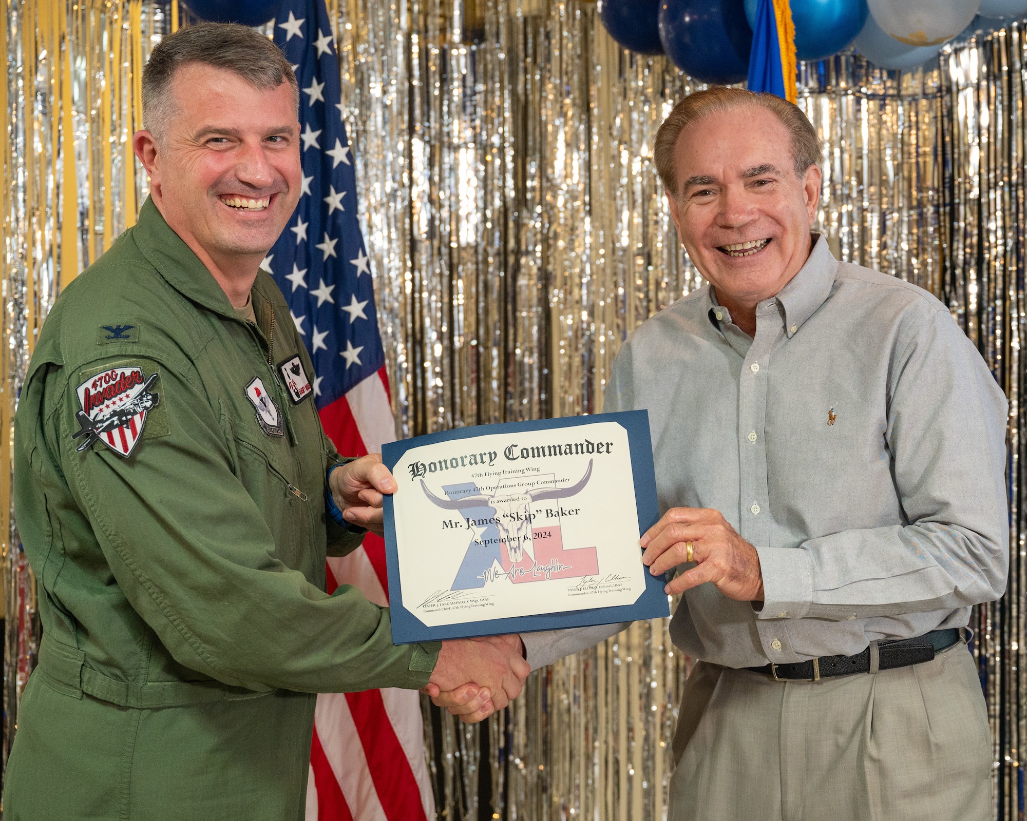 An honorary commander accepts their certificate from their commander at the honorary commander induction ceremony at Laughlin Air Force Base, Texas, Sept. 6, 2024. The honorary commander program looks to bring local community leaders and base personnel closer together, fostering the close relationship between Del Rio and Laughlin. (U.S. Air Force photo by Staff Sgt. Nicholas Larsen)