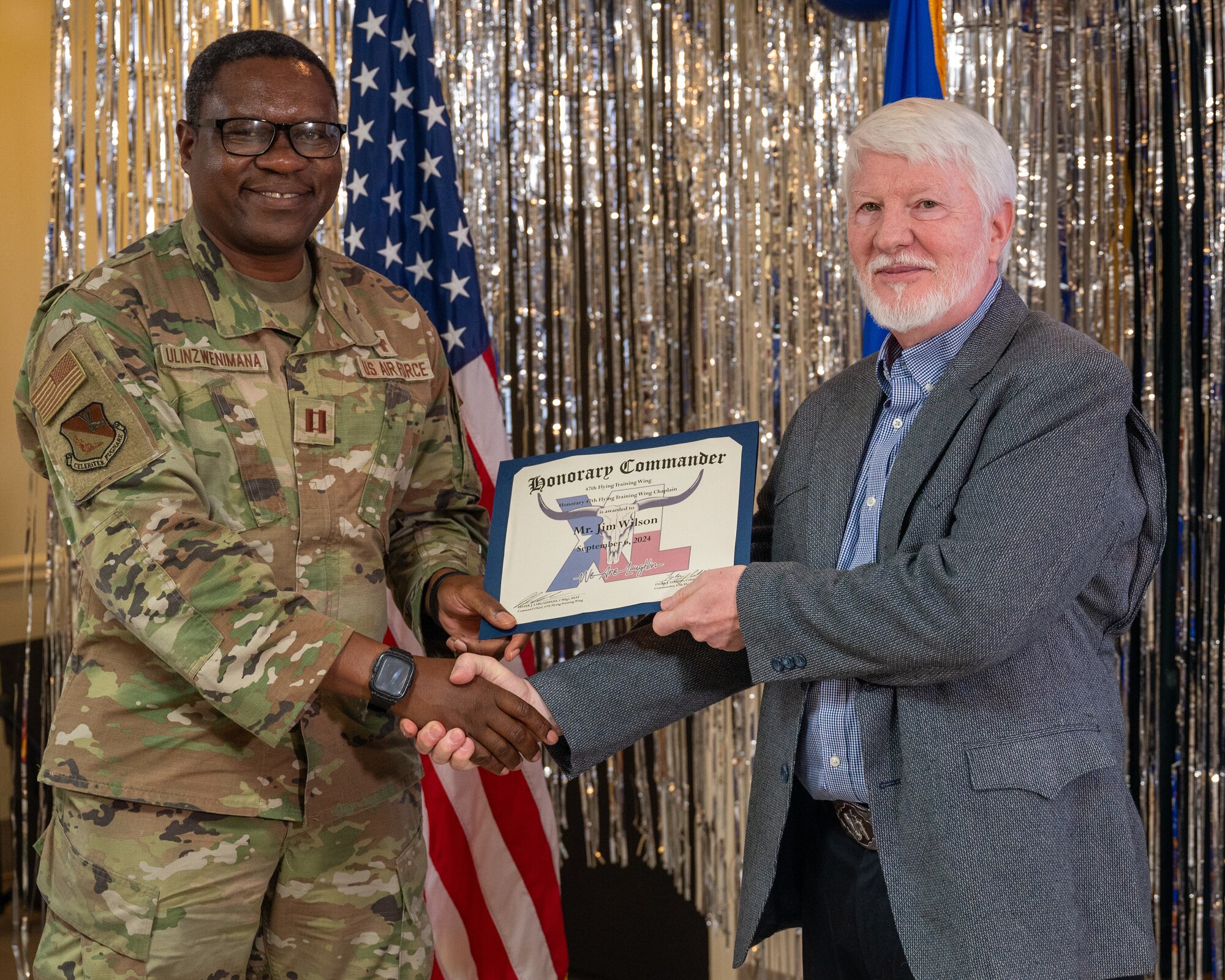 An honorary commander accepts their certificate from their commander at the honorary commander induction ceremony at Laughlin Air Force Base, Texas, Sept. 6, 2024. The honorary commander program looks to bring local community leaders and base personnel closer together, fostering the close relationship between Del Rio and Laughlin. (U.S. Air Force photo by Staff Sgt. Nicholas Larsen)