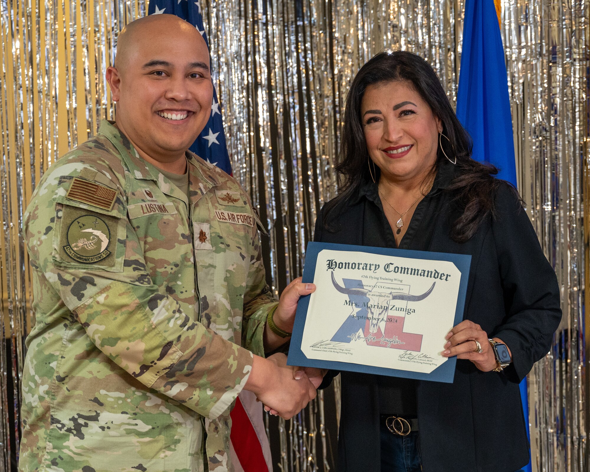 An honorary commander accepts their certificate from their commander at the honorary commander induction ceremony at Laughlin Air Force Base, Texas, Sept. 6, 2024. The honorary commander program looks to bring local community leaders and base personnel closer together, fostering the close relationship between Del Rio and Laughlin. (U.S. Air Force photo by Staff Sgt. Nicholas Larsen)
