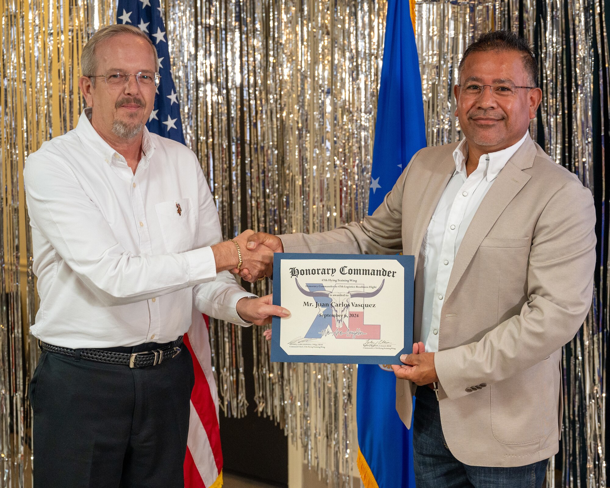 An honorary commander accepts their certificate from their commander at the honorary commander induction ceremony at Laughlin Air Force Base, Texas, Sept. 6, 2024. The honorary commander program looks to bring local community leaders and base personnel closer together, fostering the close relationship between Del Rio and Laughlin. (U.S. Air Force photo by Staff Sgt. Nicholas Larsen)