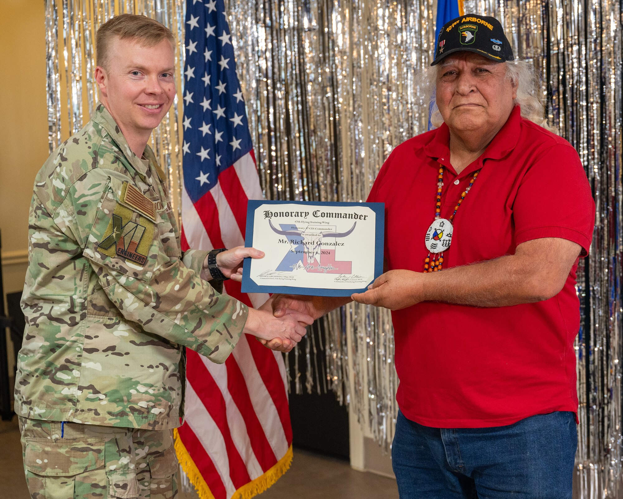 An honorary commander accepts their certificate from their commander at the honorary commander induction ceremony at Laughlin Air Force Base, Texas, Sept. 6, 2024. The honorary commander program looks to bring local community leaders and base personnel closer together, fostering the close relationship between Del Rio and Laughlin. (U.S. Air Force photo by Staff Sgt. Nicholas Larsen)