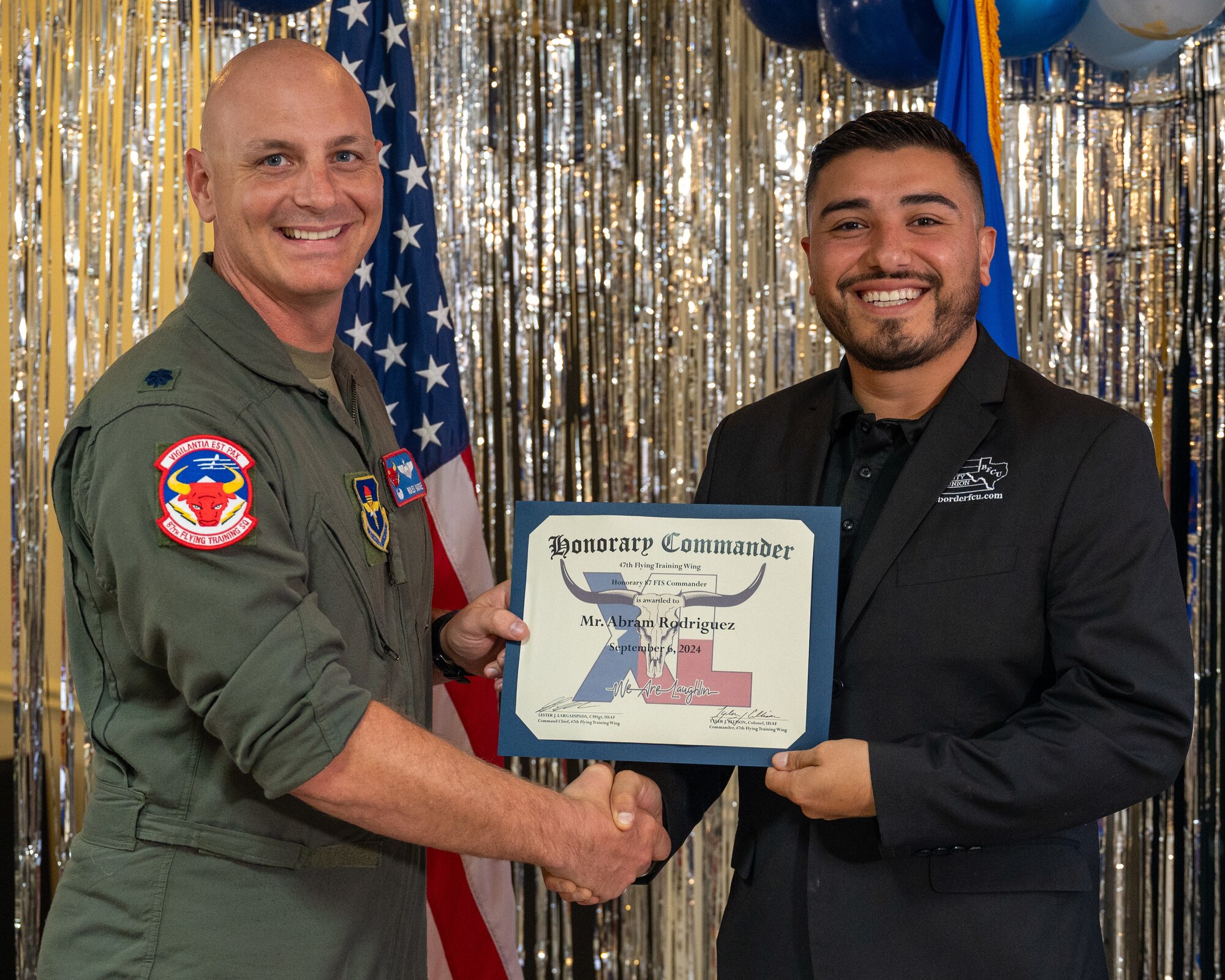 An honorary commander accepts their certificate from their commander at the honorary commander induction ceremony at Laughlin Air Force Base, Texas, Sept. 6, 2024. The honorary commander program looks to bring local community leaders and base personnel closer together, fostering the close relationship between Del Rio and Laughlin. (U.S. Air Force photo by Staff Sgt. Nicholas Larsen)