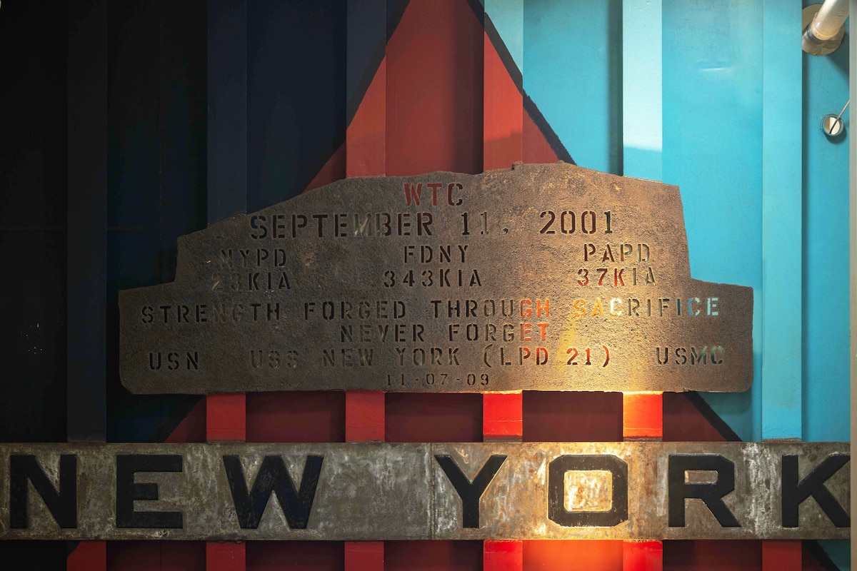 A steel sign with small lettering and larger letters spelling New York.
