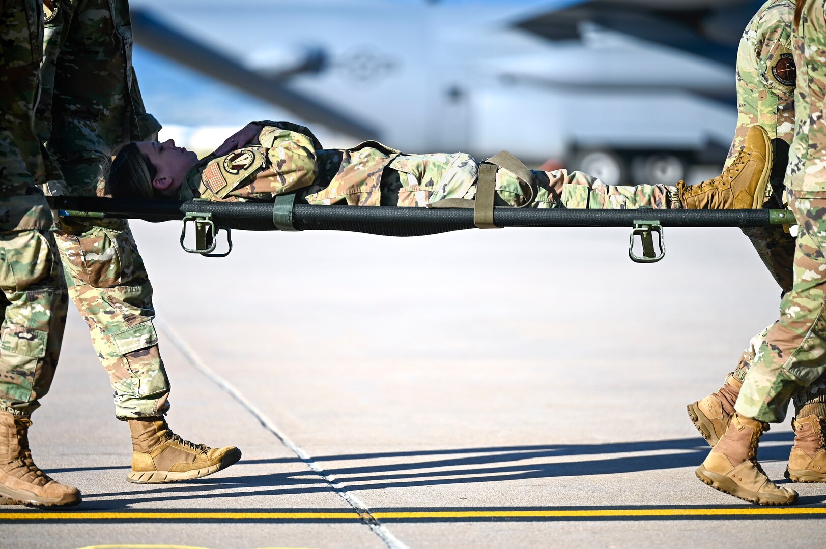 Airmen from the 21st Medical Group carry an individual on a medical stretcher during a training at Peterson Space Force Base, Colorado, Sept. 4, 2024. The 21st MDG and the 21st Security Forces Squadron partnered with the 302nd Airlift Wing to train on patient on-loading and off-loading from an aircraft. (U.S. Space Force photo by Staff Sgt. Natalie Rubenak)