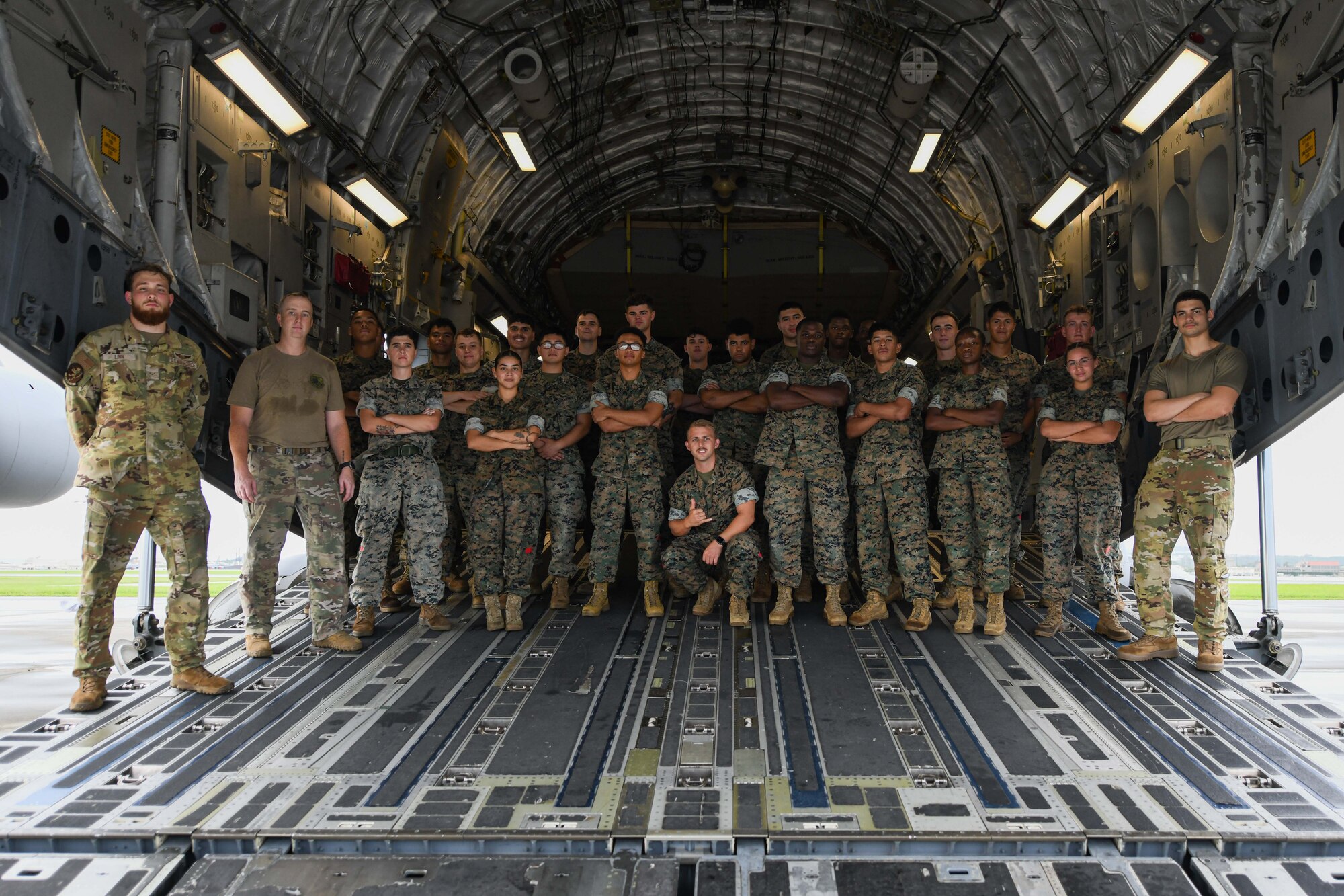 Marines and Airmen pose for a photo in the back of a C-17 Globemaster III.