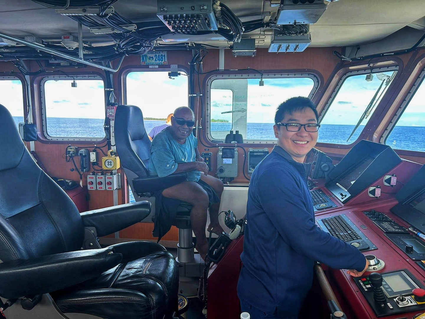 Ensign Matt Go and Chief Robert Etiuweliug, chief of the community on Satawal, take a moment for a photo on the bridge of the USCGC Oliver Henry (WPC 1140), offshore of Satawal, Yap State, Federated States of Micronesia. The Oliver Henry crew hosted Chief Etiuweliug after safely returning six rescued fishermen and their 22-foot fiberglass boat to the community. (U.S. Coast Guard photo by Lt. Ray Cerrato)