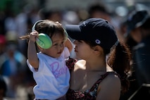 A child plays with her ear protections while being held by her mother during Misawa Air Fest at Misawa Air Base, Japan, Sept. 8, 2024.