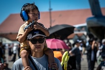 A child plays with his toy while sitting on his father shoulders at Misawa Air Fest at Misawa Air Base, Japan, Sept. 8, 2024.