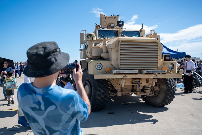 An Air Fest 2024 attendee photographs a Mine-Resistant Ambush Protected  vehicle during Air Fest 2024 at Misawa Air Base, Japan, Sept. 8, 2024.