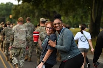 Two people briefly stop walking to pose for a photo