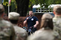 A firefighter addresses Airmen in formation