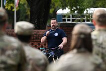 A firefighter addresses Airmen in formation