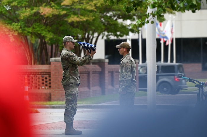 Two U.S. Air Force Airmen fold an American flag