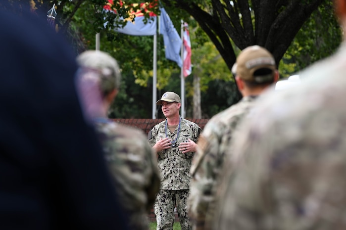 A U.S. Navy Sailor speaks to service members in formation.
