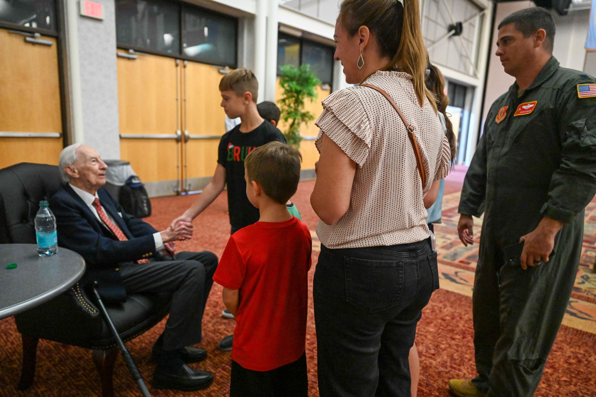 Retired Maj. John “Lucky” Luckadoo meets an Airman and his family Sept. 6, 2024, at McConnell Air Force Base, Kansas. Luckadoo was stationed at McConnell during World War II in the 350th Bomb Squadron. The visit reminded future generations of the sacrifices made by his generation. (U.S. Air Force photo by Senior Airman William Lunn)