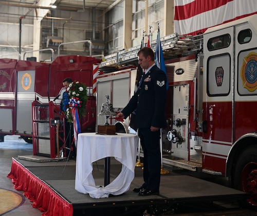 U.S. Air Force Staff Sgt. Robert Kirkpatrick, 312th Training Squadron instructor, rings the bell five times during the 9/11 ceremony at the Louis F. Garland Department of Defense Fire Academy, Goodfellow Air Force Base, Texas, September 11, 2024. The bell ceremony is a tradition in the firefighting community that signals the end of a firefighter's watch. (U.S. Air Force photo by Airman 1st Class Madi Collier)