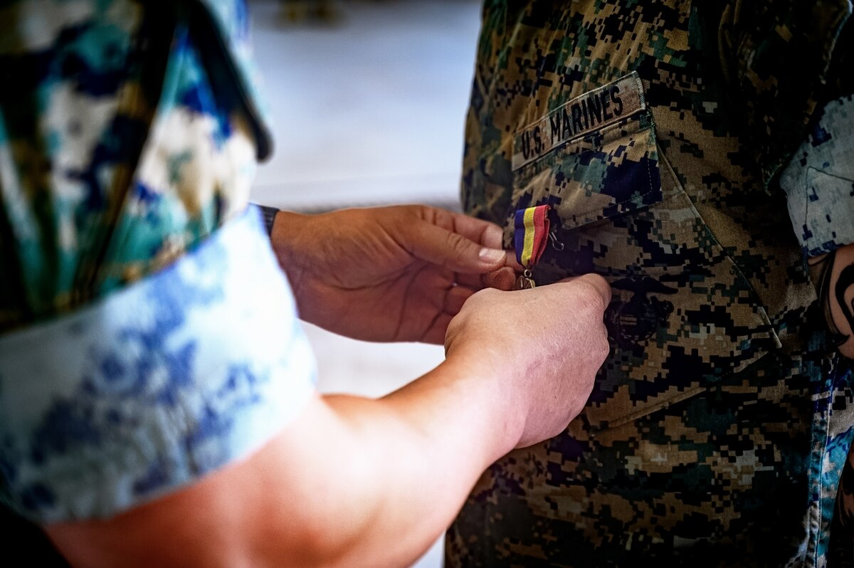 U.S. Marine Corps Col. Pablo Torres, Marine Aircraft Group 49 commanding officer, pins the Navy and Marine Corps Medal on Sgt. Andrew Gomez, MAG 49 aviation supply specialist, during an award ceremony at Joint Base McGuire-Dix-Lakehurst, N.J., Aug. 14, 2024. Gomez received the Navy and Marine Corps Medal for extricating a passenger from a burning vehicle on June 19, 2023. (U.S. Air Force photo by Senior Airman Matt Porter)