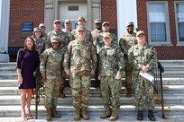 Members of the Air Force District of Washington and Naval District Washington, lead by U.S. Navy Rear Admiral David Faehnle, commandant of NDW and U.S. Air Force Major Gen. Daniel DeVoe, commander of AFDW, pose in front of the Enterprise dormitories during an Unaccompanied Housing visit at Joint Base Anacostia-Bolling, Washington, D.C., Sept. 4, 2024. The purpose of this visit was to present the JBAB dorm conditions and plans to improve the living spaces for JBAB’s junior enlisted members. (U.S. Air Force photo by Airman 1st Class  Shanel Toussaint)