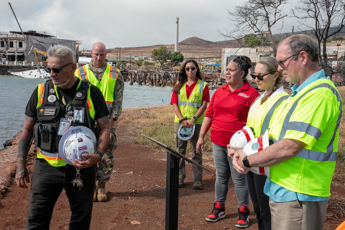 Acting Assistant Secretary of Defense for Homeland Defense and Hemispheric Affairs, Rebecca Zimmerman (second from right) attends a traditional Pule (or prayer) ceremony August 29, 2024 and learns about Lahaina’s history at the historic Hauola Stone (healing stone or birthing stone) in Lahaina, Hawaii. Also, in attendance are (from left to right) Ke’eaumoku Kapu, Na Aikane o Maui Cultural Observer; Lt. Col. Collin Jones,  Recovery Field Office Commander; Mehana Hind, Council for Native Hawaiian Advancement and USACE Cultural Advisor; Darcy Calabria, USACE Archaeologist; and Mr. James Ross,  Director, Defense Support of Civil Authorities. (U.S. Army Corps of Engineers photo by Mark Haviland)