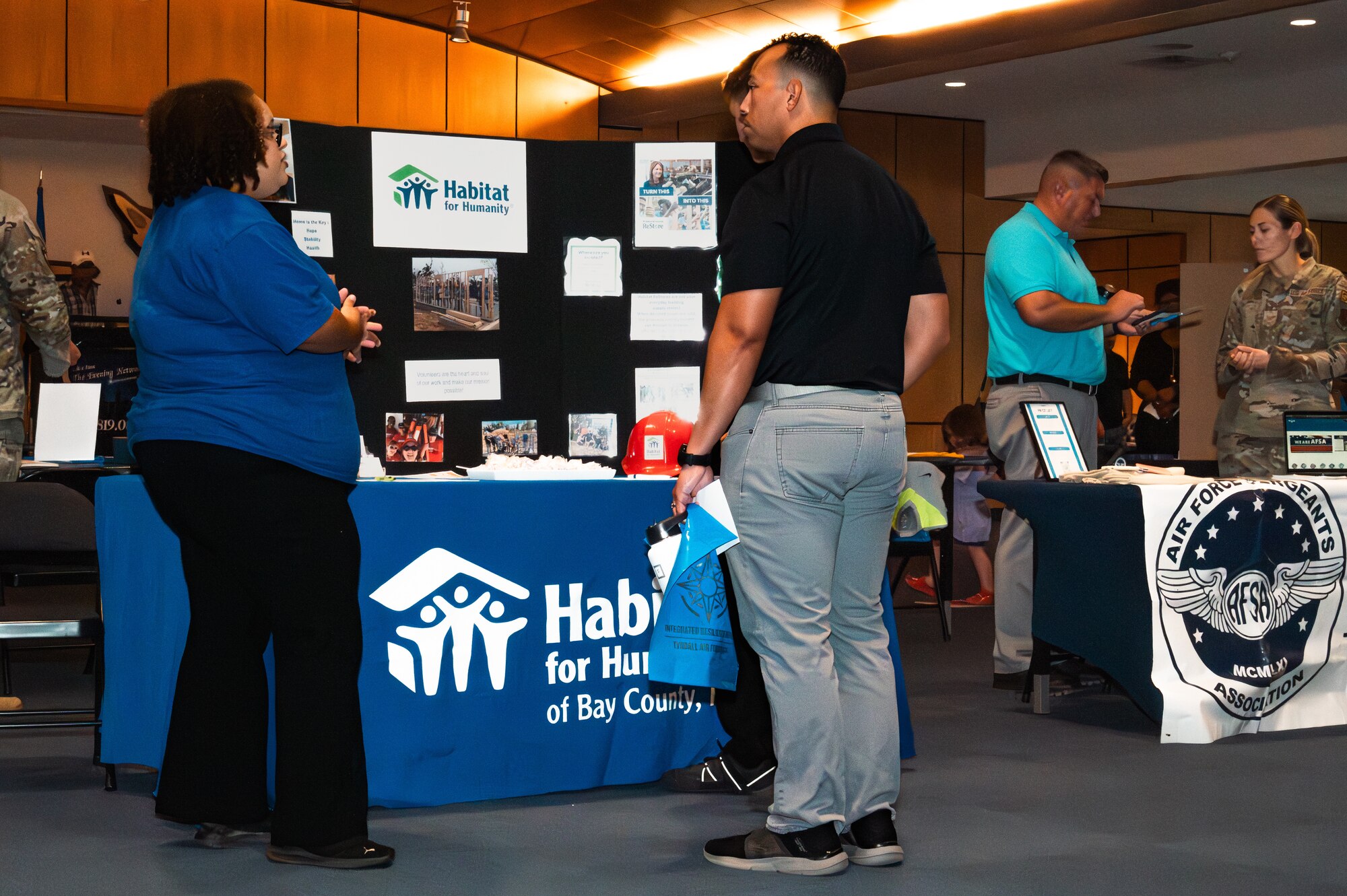 Tyndall community members speak with a representative from Habitat for Humanity of Bay County, Fla. during the Tyndall Connects expo