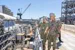 Rear Adm. Todd Weeks, program executive officer, Strategic Submarines, and Capt. Tim Clark, program manager, In Service Strategic Submarines, Naval Sea Systems Command, observe maintenance operations in Dry Dock 4 July 16, 2024, during a visit with the various submarine project teams at Puget Sound Naval Shipyard & Intermediate Maintenance Facility in Bremerton, Washington. (U.S Navy photo by Jeb Fach)