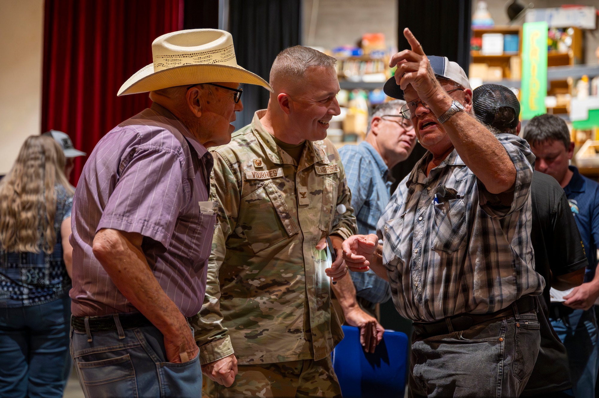 A military man speaks to two other men.
