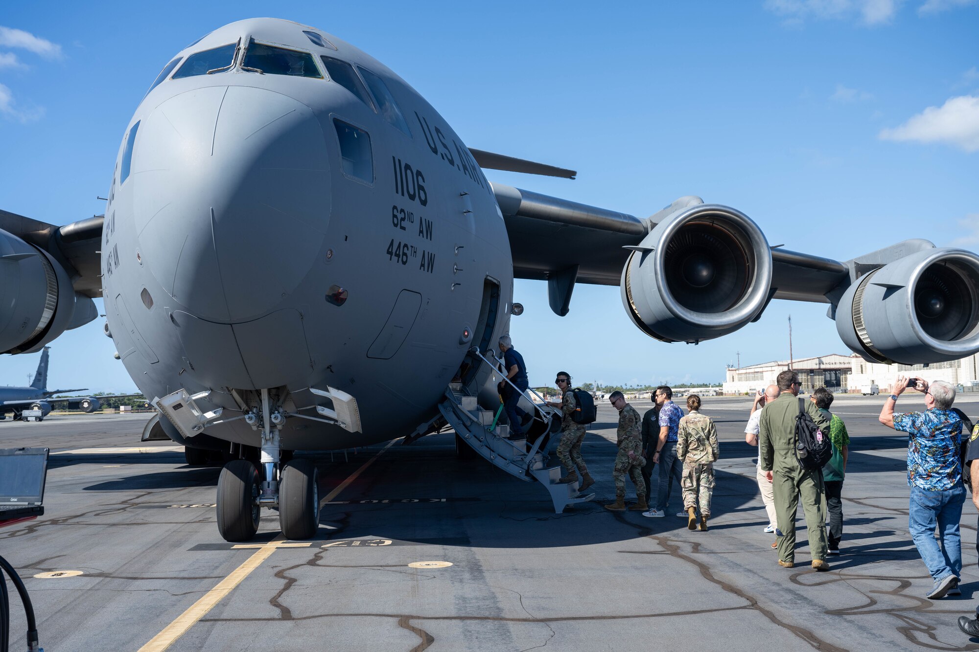 Airmen and civilians board an aircraft.
