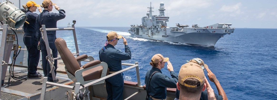 U.S. Sailors aboard the Arleigh Burke-class guided-missile destroyer USS Russell (DDG 59) salutes the flagship of the Italian Navy aircraft carrier ITS Cavour (CV 550) during divisional tactics maneuvering in the South China Sea, Sept. 10, 2024.