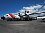 Members from Coast Guard Air Station Barbers Point, Hawai'i Fire Department, Ocean Safety and the Department of Land and Natural Resources stand for a photo in front of a HC-130 Hercules airplane in Kawaihae, Hawai'i, Sep. 12, 2024.