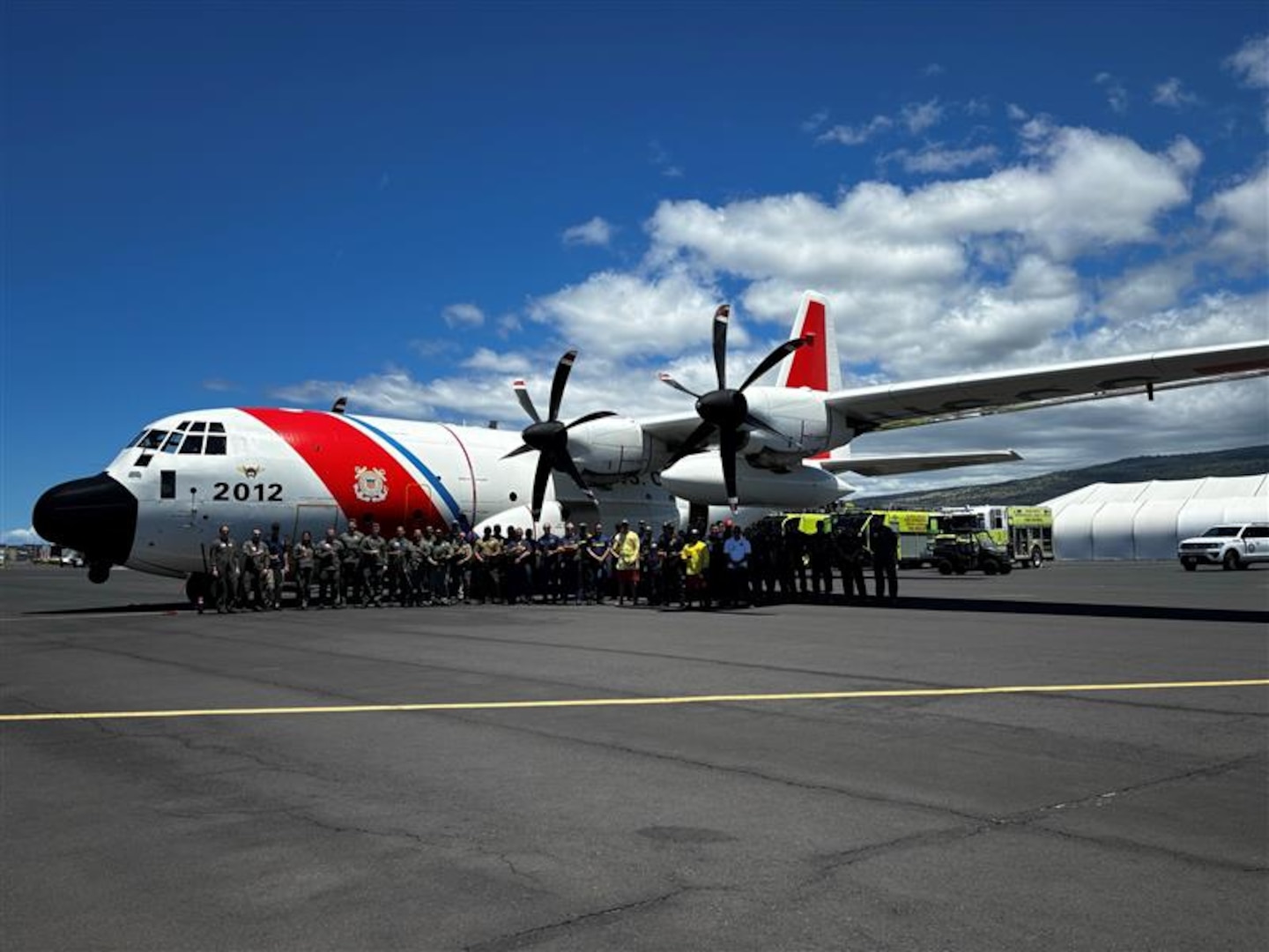 Members from Coast Guard Air Station Barbers Point, Hawai'i Fire Department, Ocean Safety and the Department of Land and Natural Resources stand for a photo in front of a HC-130 Hercules airplane in Kawaihae, Hawai'i, Sep. 12, 2024.