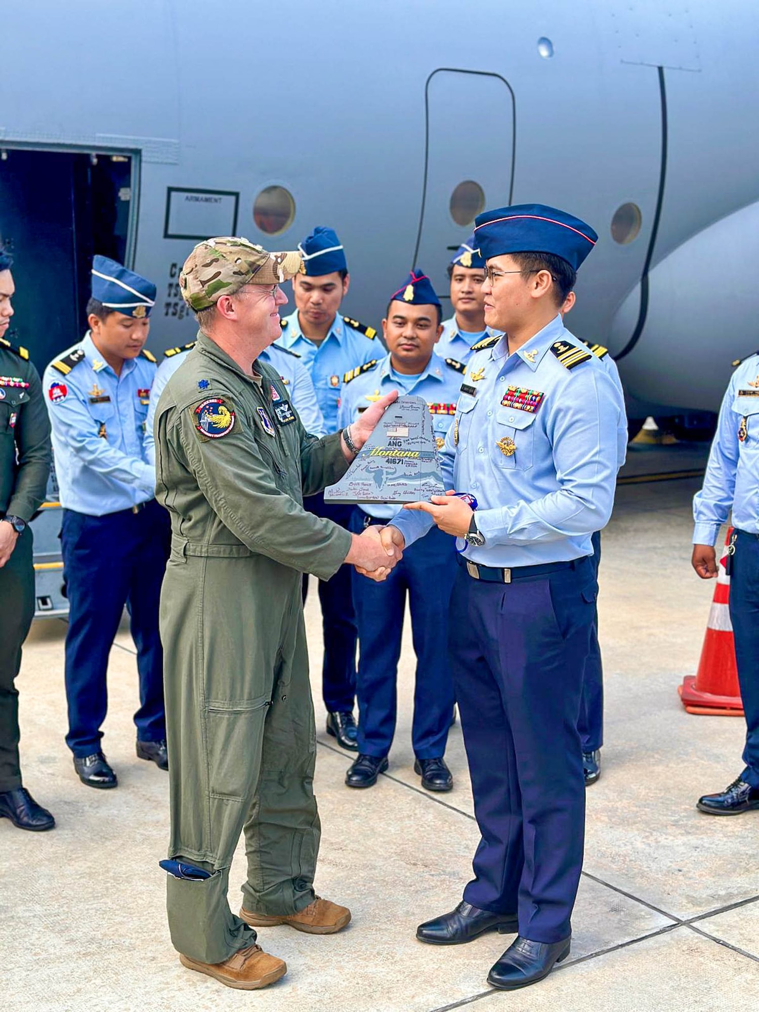 A Montana Air National Guard Airman interacts with a Royal Cambodian Air Force officer while the unit’s C-130J Hercules refuels at the Phnom Penh International Airport for the joint military exercise Atlas-Angel in Phnom Penh, Cambodia.