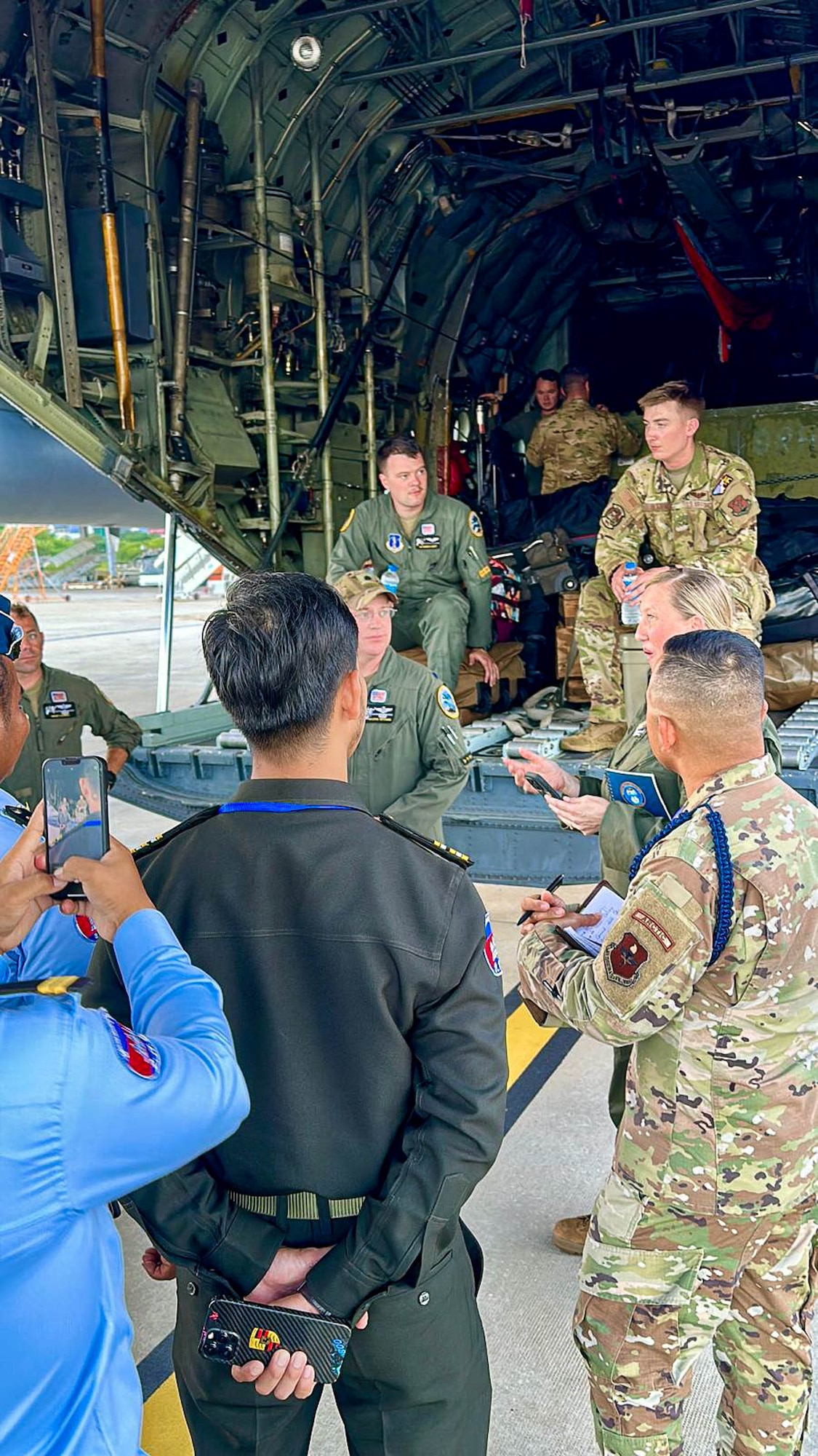 Montana Air National Guard Airmen interact with the Royal Cambodian Air Force officers while the unit’s C-130J Hercules refuels at the Phnom Penh International Airport for the joint military exercise Atlas-Angel in Phnom Penh, Cambodia.