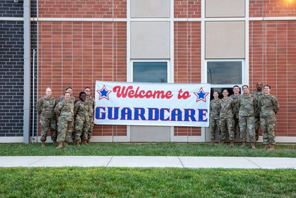 U.S. Air Force medical technicians assigned to the Ohio National Guard’s 180th Fighter Wing pose for a photo in front of sign advertising Guard Care in Xenia, Ohio, Aug. 11, 2024. Guard members helped provide free health care to more than 1,000 people while honing their skills.