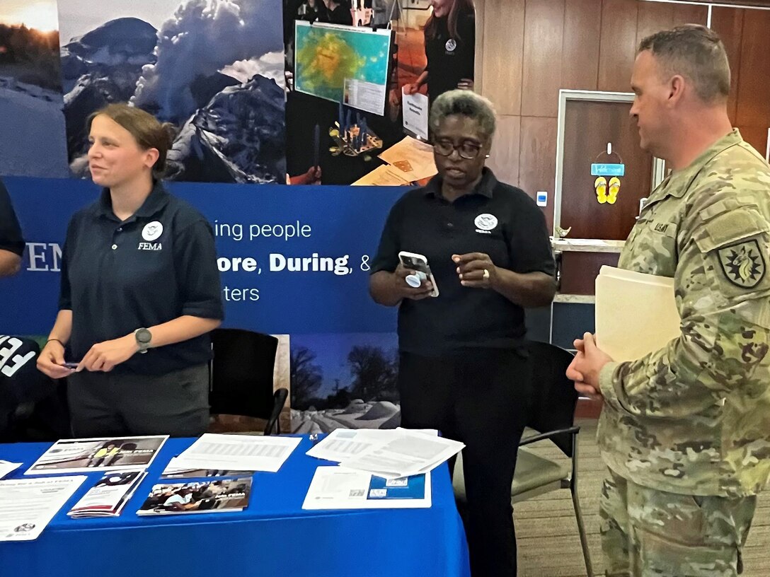 CW2 Michael Yoha speaks with FEMA representatives at a job fair