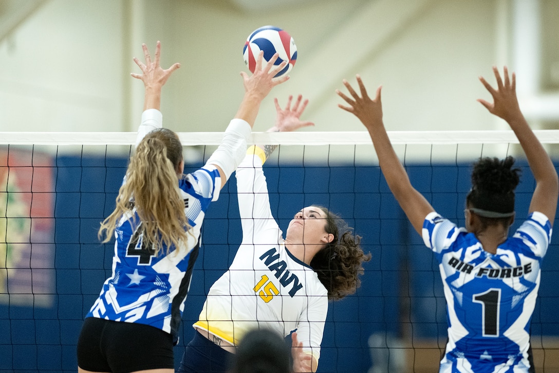 Navy middle blocker Petty Officer 3rd Class Alexis Roberson of Naval Base San Diego, Calif. crushes a spike between defenders during the 2024 Armed Forces Men’s and Women’s Volleyball Championship held at Fort Carson, Colorado 10-14 September.  Teams from the Army, Navy (with Marine Corps and Coast Guard players) and Air Force (with Space Force players) battle it out for gold.  (DoD photo by EJ Hersom)