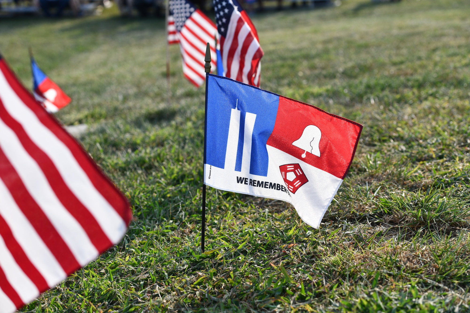 A 9/11 remembrance flag stands with American flags around the 9/11 memorial at American Heroes Park in Bellevue, Neb., on Sept. 11, 2024.  Bellevue hosted a 9/11 remembrance ceremony honoring those who died in the events of 9/11 as well as the military members who gave their lives in the war on terror. (U.S. Air Force photo by Chad Watkins)