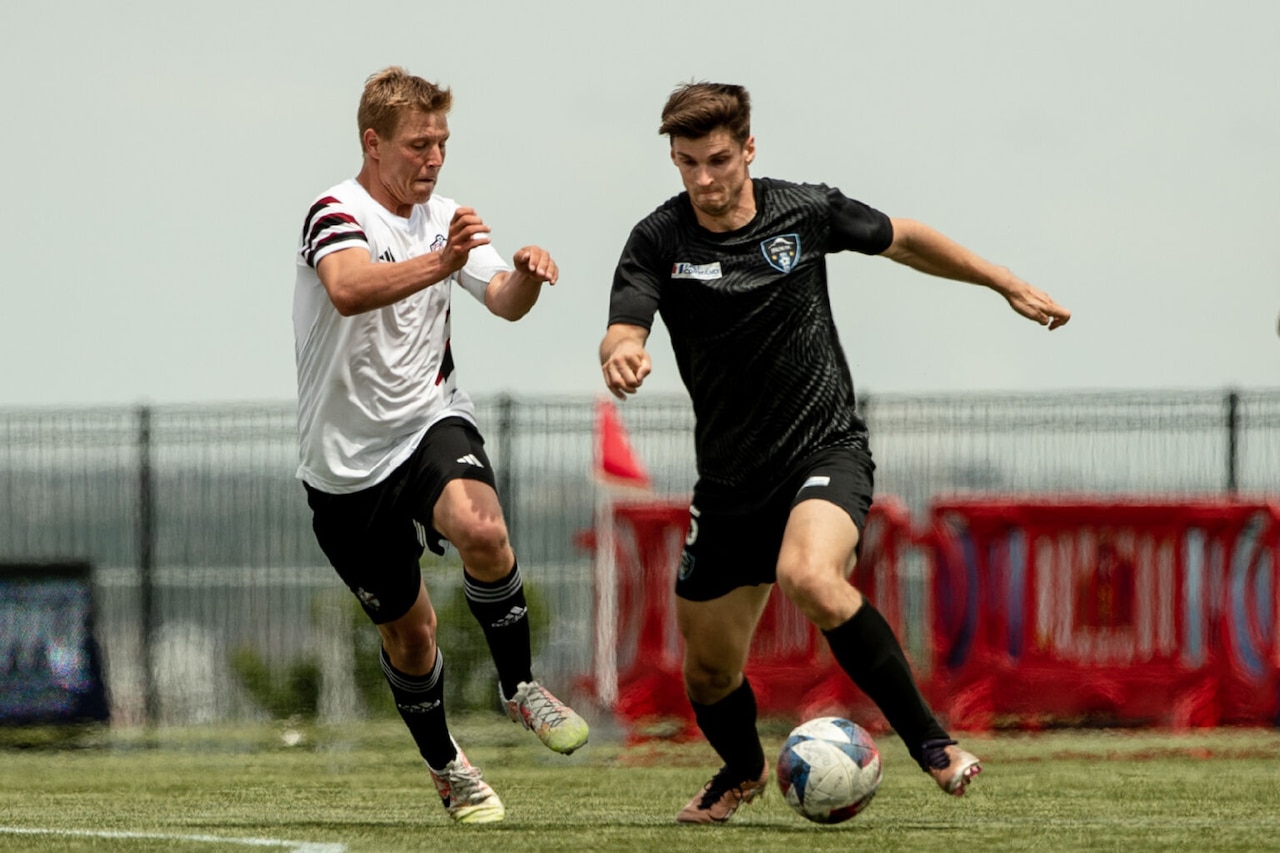 Soccer players scramble for the ball.