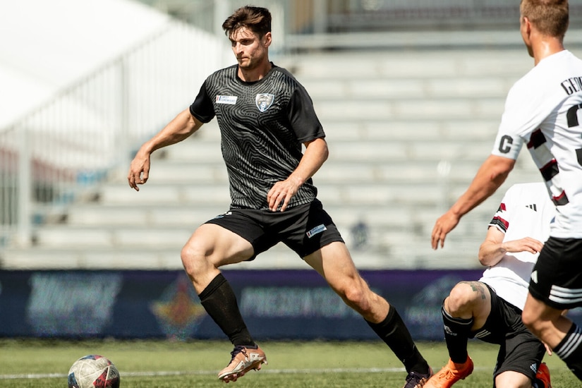 Soccer players scramble for the ball.