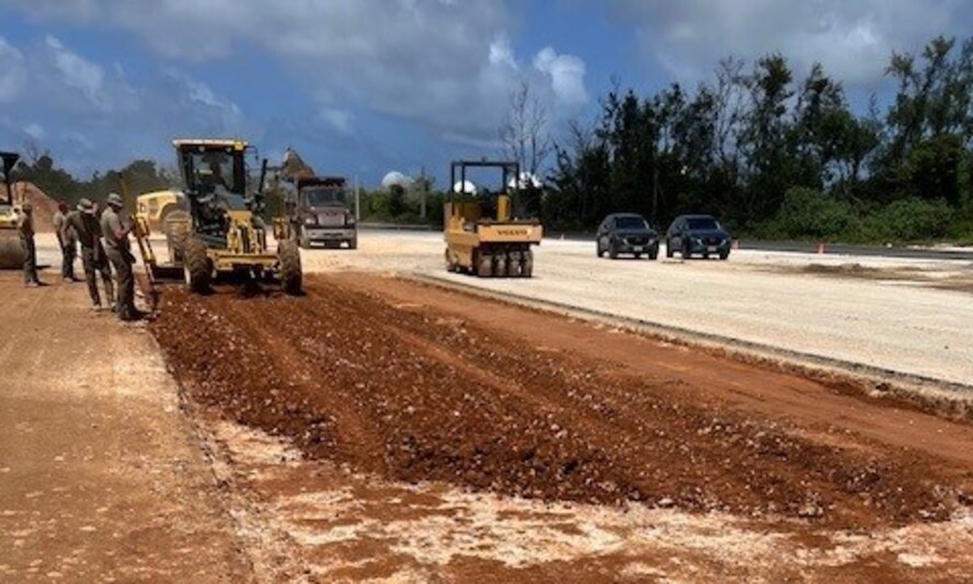 Military members operate heavy machinery equipment to excavate a portion of runway.