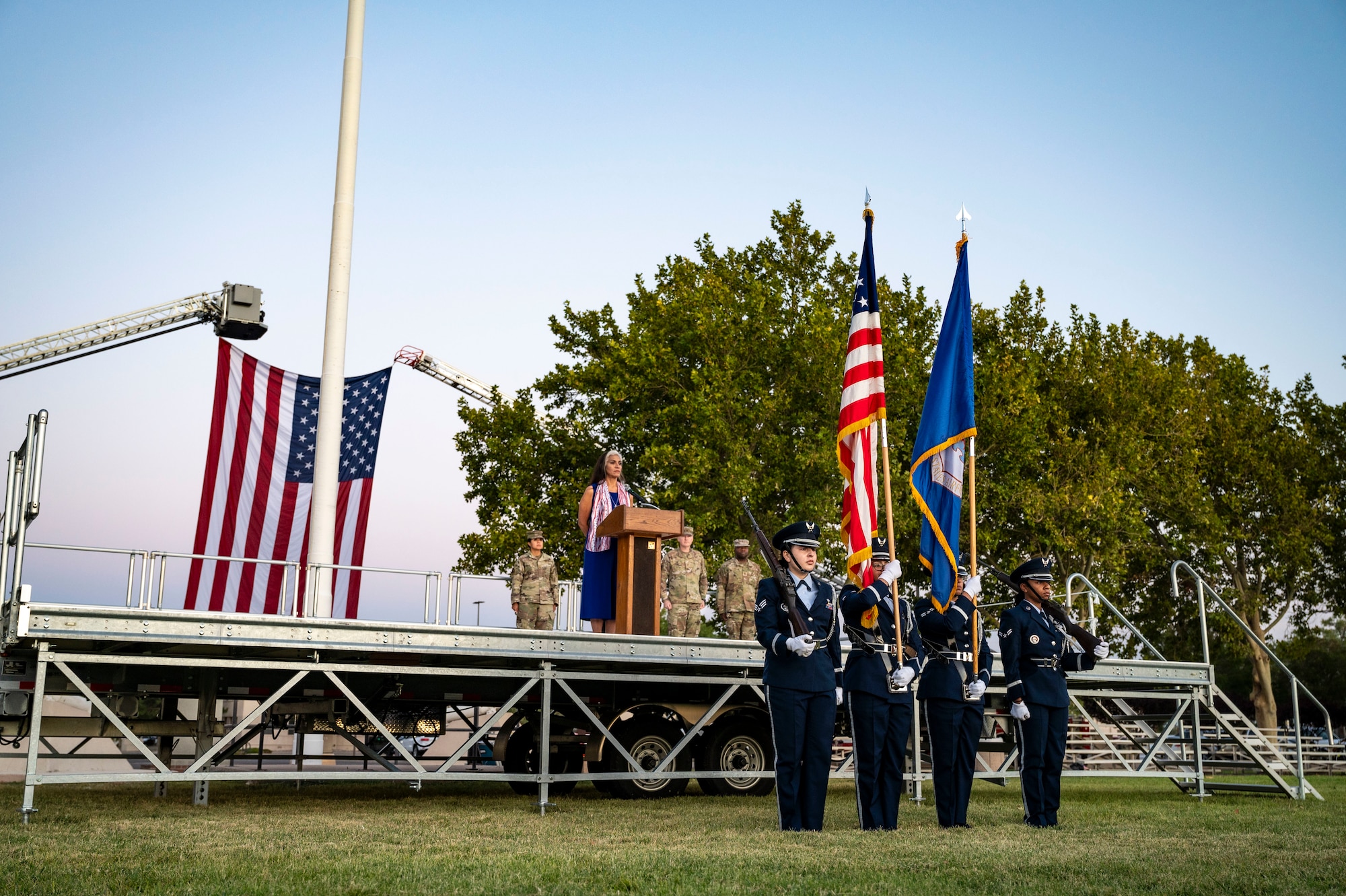 People holding flags in front of a stage.
