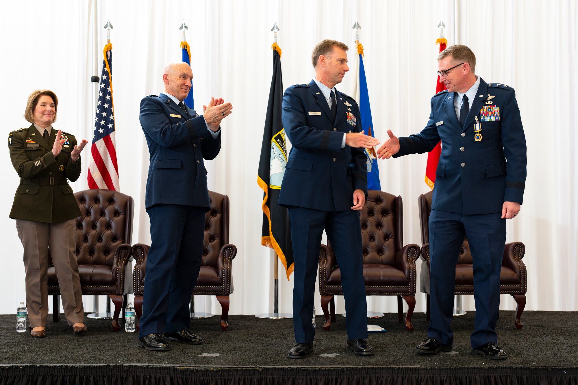 Maj. Gen. Evan Pettus, outgoing Air Forces Southern commander, right, shakes hands with Maj. Gen. David Mineau, center, newly-appointed AFSOUTH commander after completing a Change of Command ceremony at Davis-Monthan Air Force Base, Arizona, Sep. 11, 2024. At the direction of the Secretary of the Air Force, Air Forces Southern was elevated to a Service Component Command.  The Air Force is organizing its major commands, or MAJCOMs, into Institutional Commands, responsible for organizing, training, and equipping Airmen, and Service Component Commands, responsible for preparing Airmen for warfighting in a combatant command’s area of responsibility. The changes are part of the Department of the Air Force’s Great Power Competition initiative. (U.S. Air Force photo by Tech. Sgt. Rachel Maxwell)