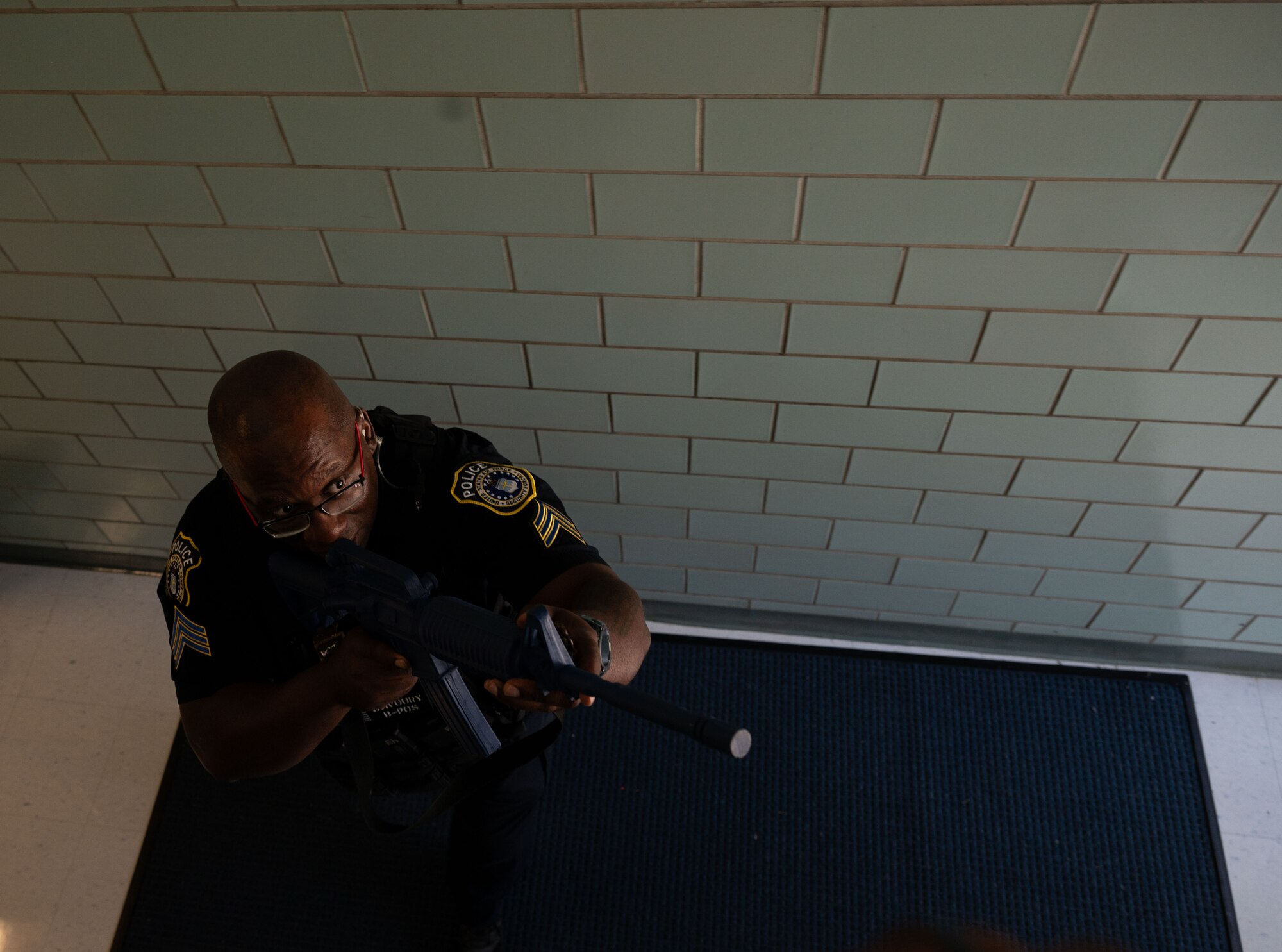 Officer Conrad Savoury, 436th Security Forces Squadron flight sergeant, demonstrates how to properly clear a flight of stairs during school shooter response training at Dover, Delaware, Sept. 10, 2024. The training was used to aid the 436th Security Forces Squadron in reaffirming readiness. (U.S. Air Force Photo by Senior Airman Dieondiere Jefferies)