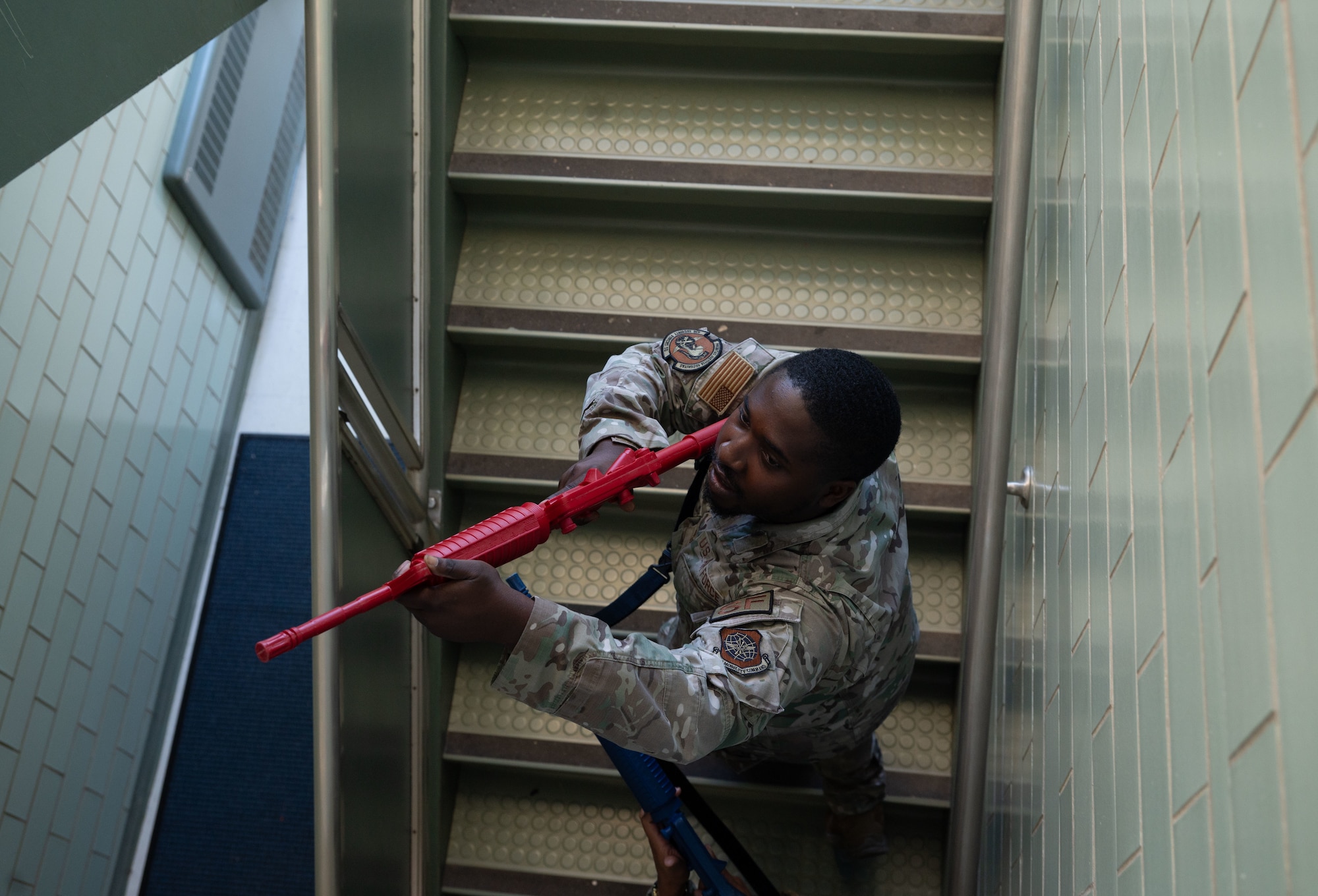 Senior Airman Kennard Watford, 436th Security Forces Squadron response force leader, clears a staircase during school shooter response training at Dover, Delaware, Sept. 10, 2024. The training was used to aid the 436th SFS in reaffirming readiness in response to an active school shooter. (U.S. Air Force Photo by Senior Airman Dieondiere Jefferies)