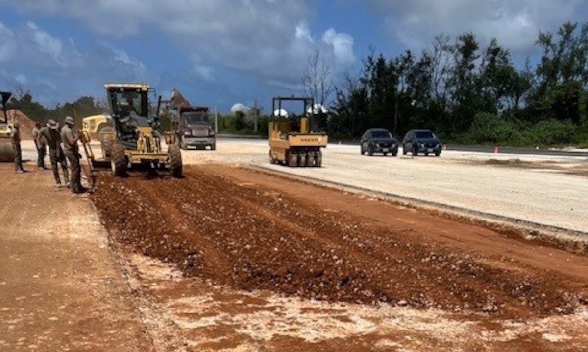 Military members operate heavy machinery equipment to excavate a portion of runway.