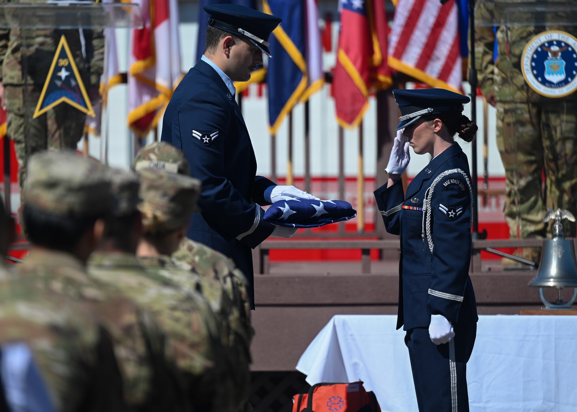 A person in uniform renders a salute to the U.S. Flag.