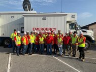 group of people standing in front of large emergency van