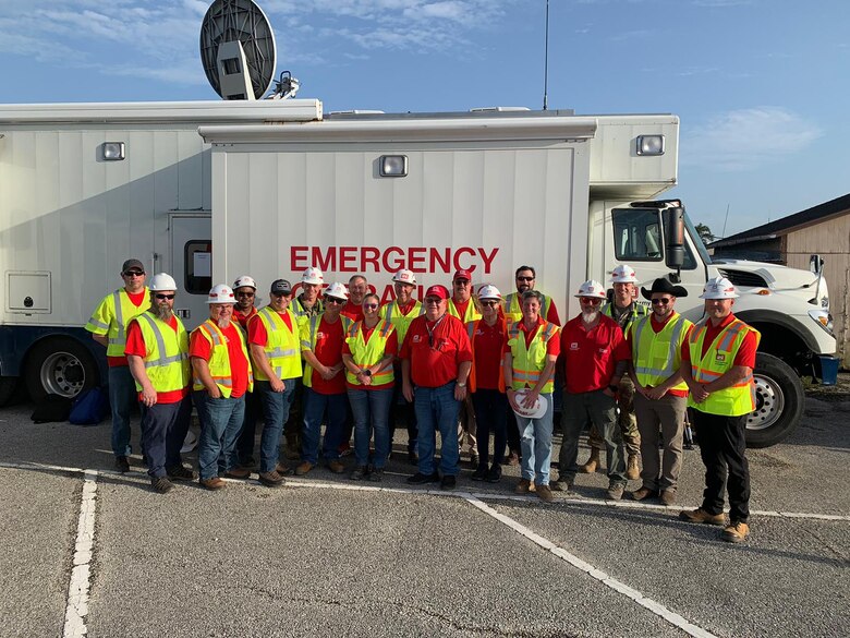group of people standing in front of large emergency van