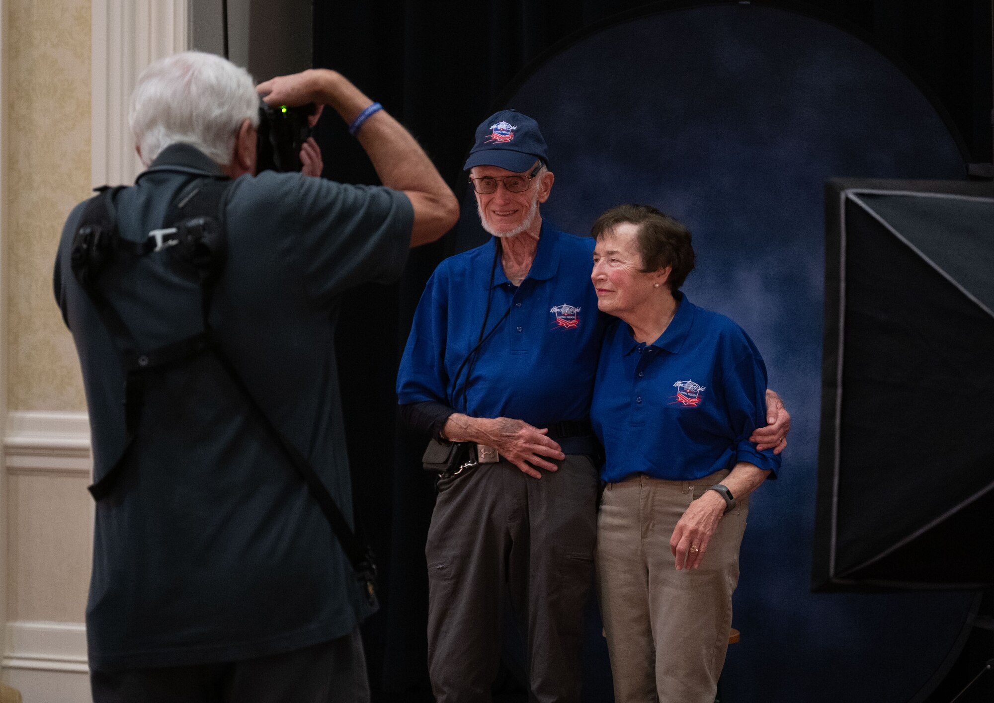 Richard Schneider, center, and Penny Schneider, right, U.S. Air Force veterans, have their picture taken for the Capital Region Honor Flight at Bally’s Dover Casino Resort, Dover, Delaware, Sept. 12, 2024. The Honor Flight is a program for U.S. veterans to visit monuments in Washington D.C. for a day, honoring them and giving proper recognition to their service. (U.S. Air Force photo by Airman Liberty Matthews)