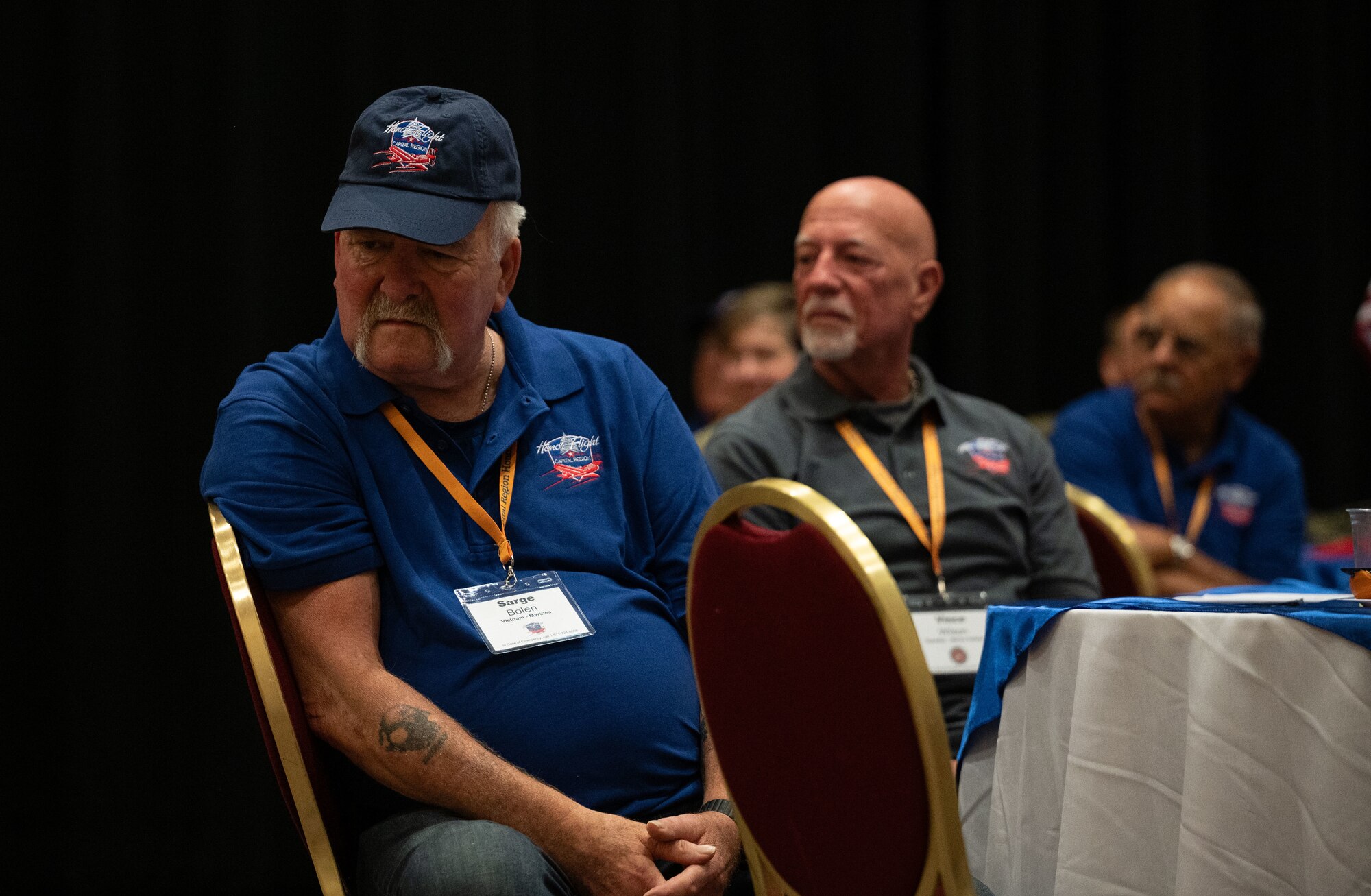 Sarge Bolen, U.S. Marine Corps veteran, listens as a speaker gives remarks at the send-off for the Capital Region Honor Flight at Bally’s Dover Casino Resort, Dover, Delaware, Sept. 12, 2024. The Honor Flight is a program for U.S. veterans to visit monuments in Washington D.C. for a day, honoring them and giving proper recognition to their service. (U.S. Air Force photo by Airman Liberty Matthews)